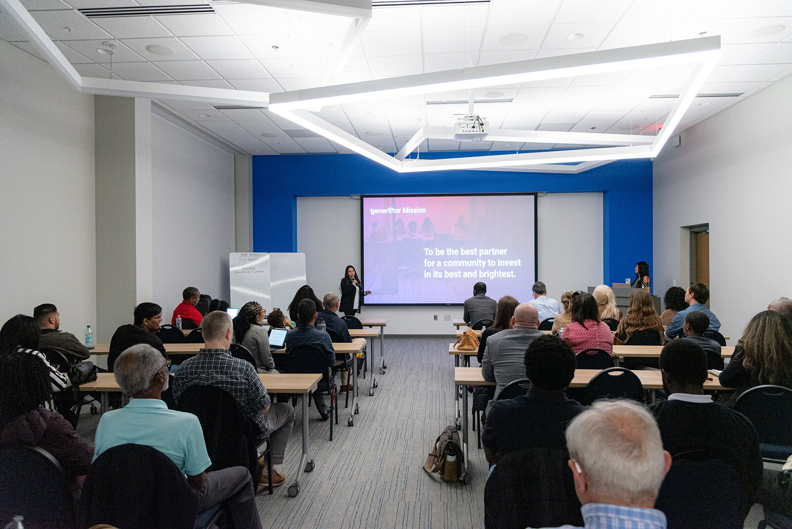 Large audience attending a startup showcase presentation at a gener8tor Spark event