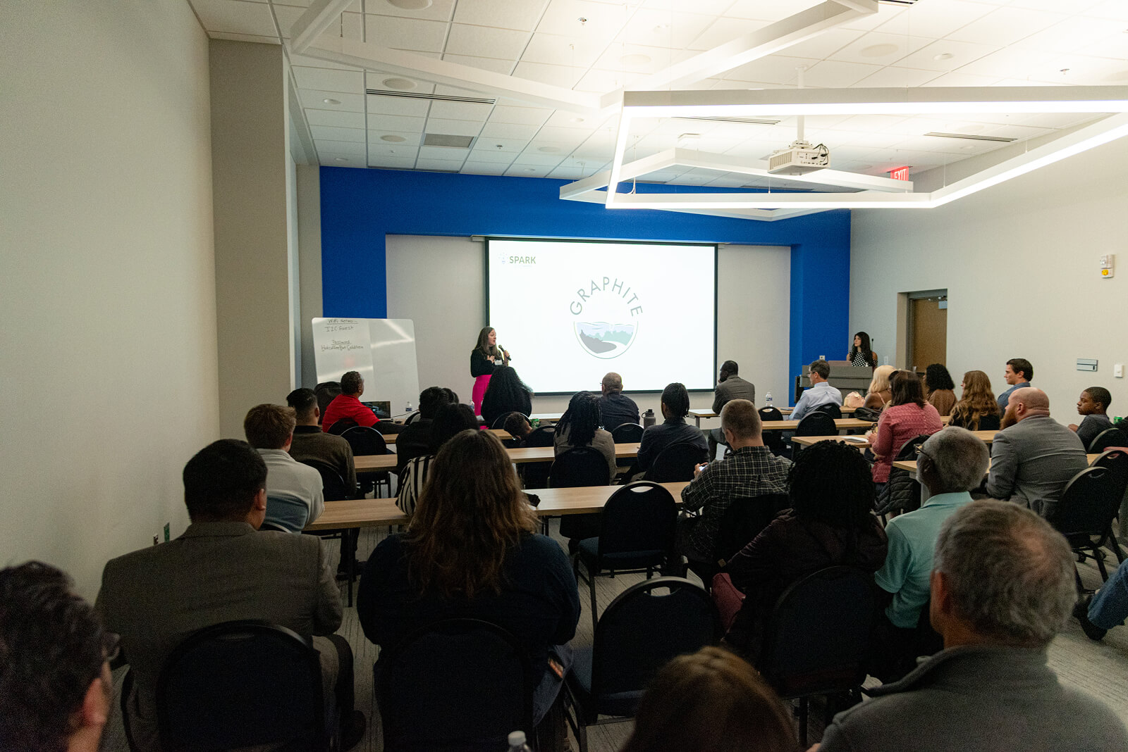 Startup founder presenting to a large group at a gener8tor Spark program event